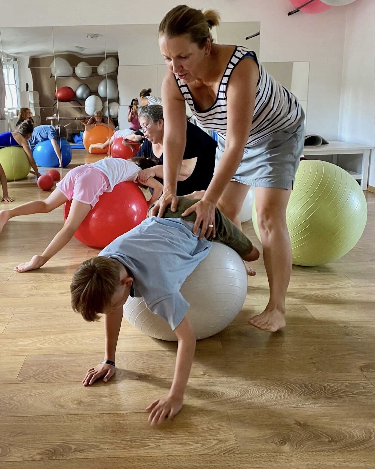 Chlapec cviči na míči s fyzioterapeutkou